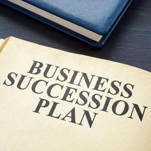 Business succession plan document on desk with blue notebook legal planning concept for firms