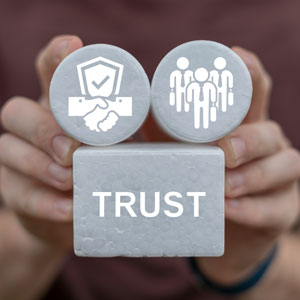 Hands holding trust blocks with icons representing security and family in estate planning
