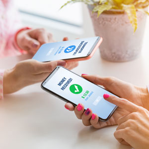 Two people using smartphones to confirm secure money transfer – wealth planning legal concept